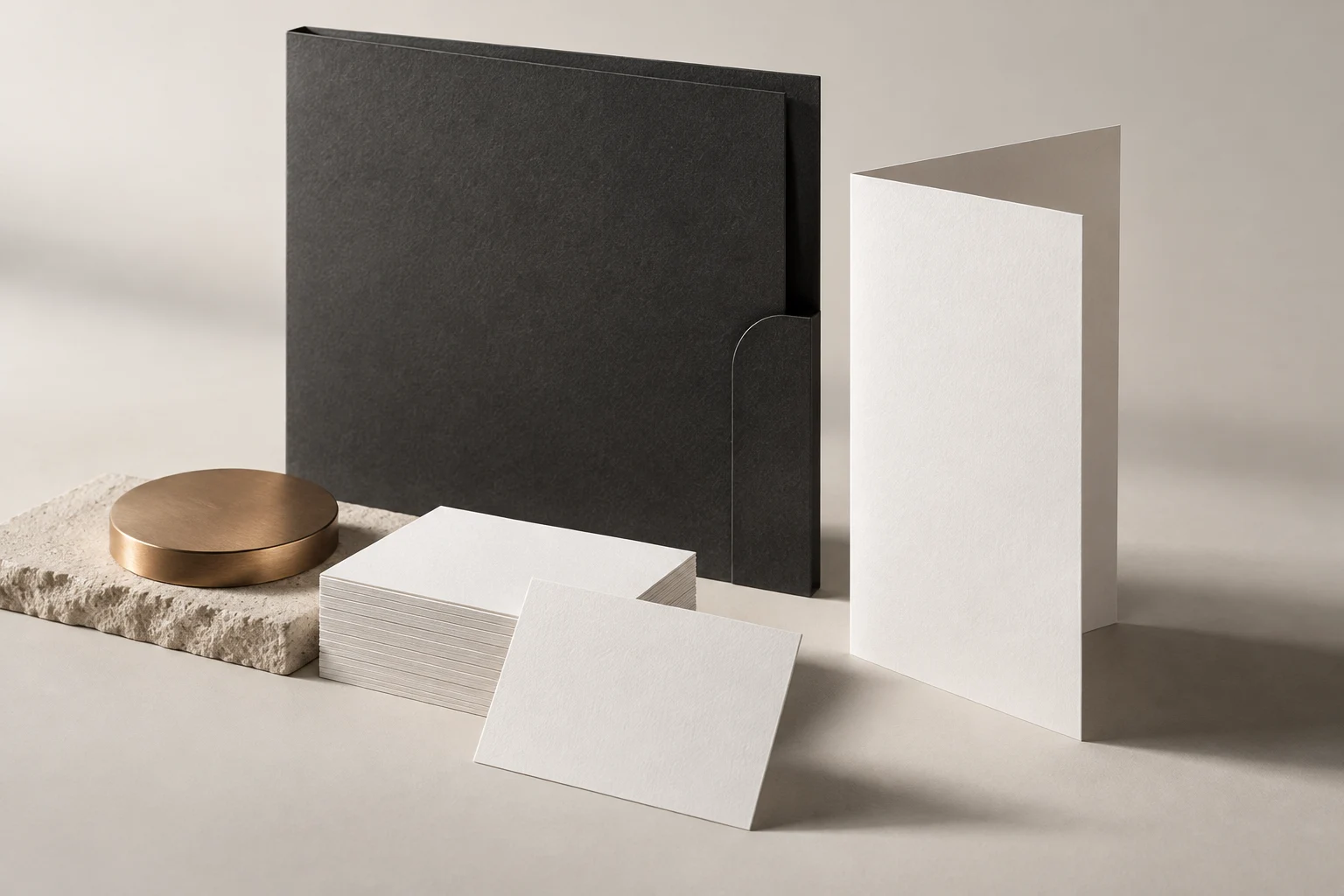 A sculptural study of white stationery, charcoal print and warm bronze details